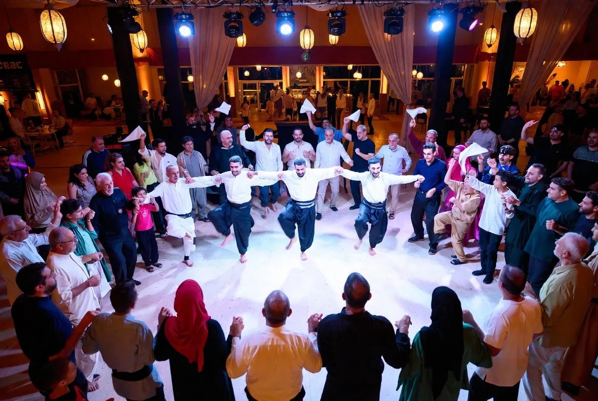 רקדני דבקה במעגל עם אורחים באירוע מזרחי — כולם רוקדים ביחד