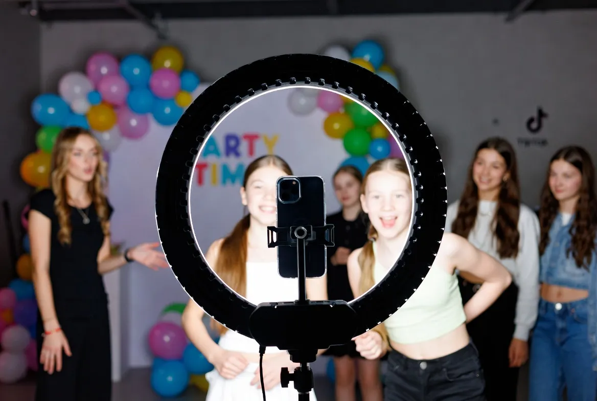 פינת צילום טיקטוק עם רינג לייט באירוע — רקדנית ואורחים מצלמים סרטון