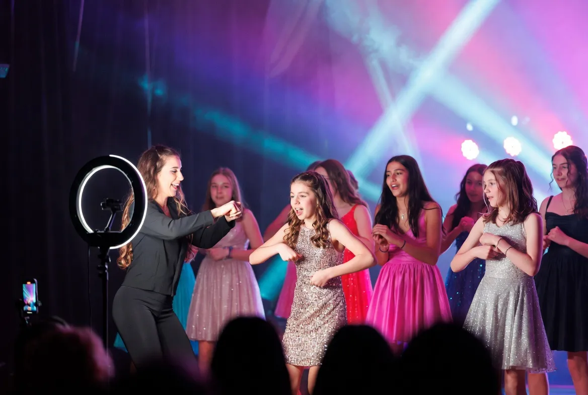 ריקוד TikTok על הבמה — יובלנית עם רקדניות בבת מצווה