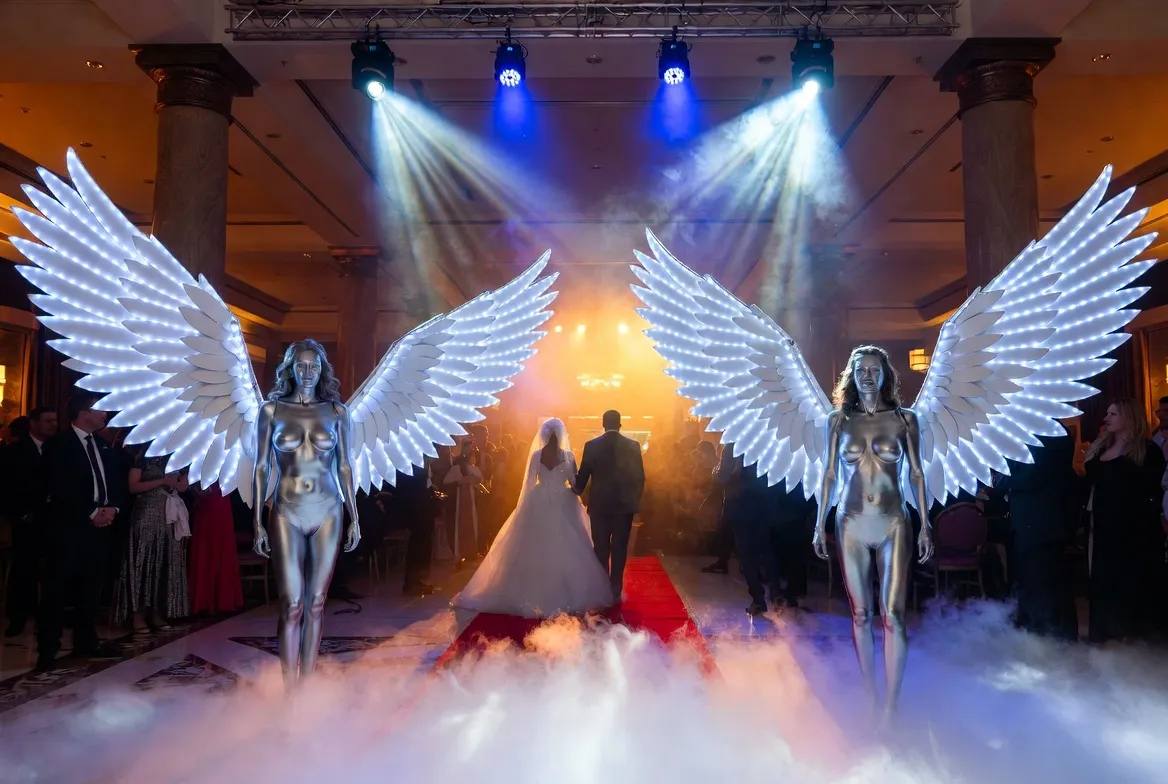 מייצגים עם כנפי LED בכניסת הזוג בחתונה בכפר המכביה